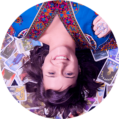 Pri Ferraz - Diário da Bruxa Pri Ferraz deitada sobre Cartas do Tarot da Bruxas